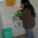 Vanessa llenando los dispensadores plásticos de jabón.